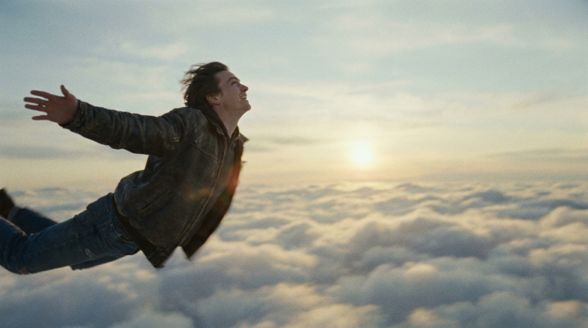 Traumdeutung Fliegen – Person schwebt frei durch goldene Wolken