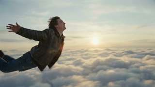 Traumdeutung Fliegen – Person schwebt frei durch goldene Wolken