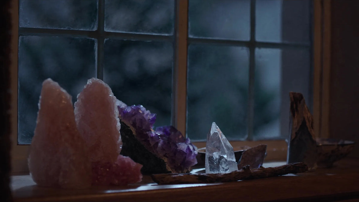 Kristalle (Rosenquarz, Amethyst, Bergkristall) auf Fensterbank im Mondlicht