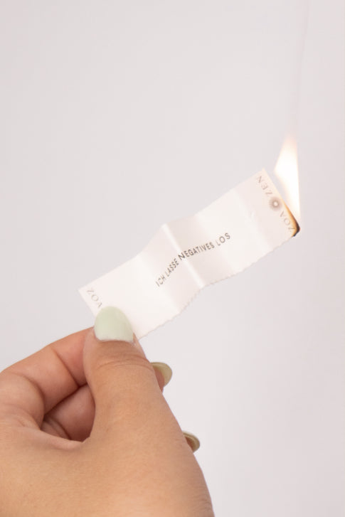 Hand hält brennendes ZoaZen Räucherpapier – Zen Paper aus Naturzutaten zum Räuchern