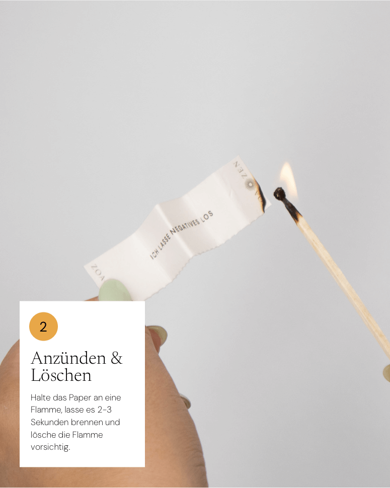 Anzünden und Löschen Anleitung: Papier wird angezündet, Hand hält einen Streichholz, neutraler Hintergrund.